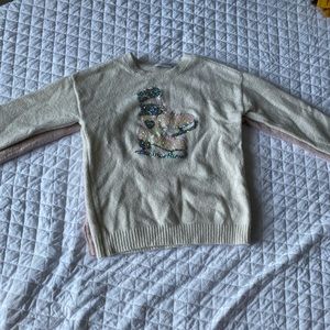 Two pairs of Christmas sweaters.